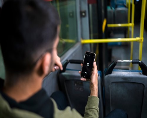 commuter looking at smartphone on bus during transit